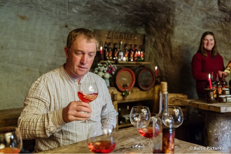 Romantiška vyno degustacija smiltainio oloje žvakių šviesoje šeimai